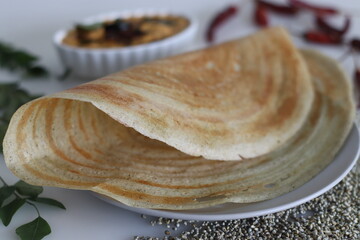Bajra ghee roast. Thin crispy crepes made with a batter of pearl millet and lentils adding ghee. Served with spicy coconut condiments