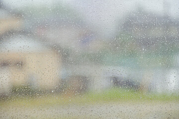 雨の日に、室内から窓ガラス越しの眺める街並み。
梅雨、台風、雨降りのコンセプト。