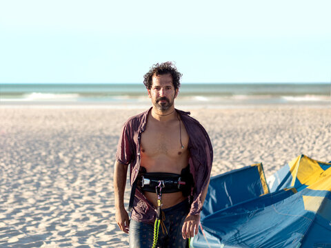 Young man on the beach after practicing kitesurfing. Selective focus.