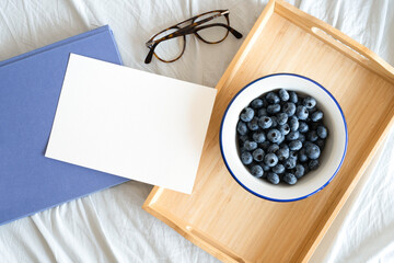blueberries in a bowl, breakfast on a tray, invitation card with space for text, picture taken from above