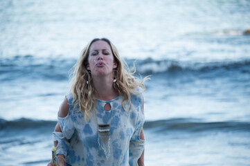 Woman in ceremony at an altar by the sea..