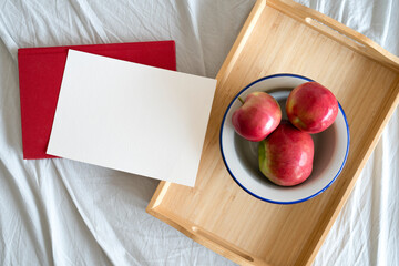 red apples in a bowl, breakfast on a tray, invitation card with space for text, picture taken from above