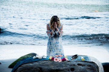 Woman in ceremony at an altar by the sea.. - 533165498