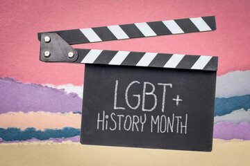 LGBT History Month, white chalk handwriting on a clapboard against abstract paper landscape,...