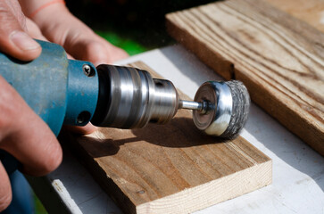Drill with a wire brush. Woodworking outdoors