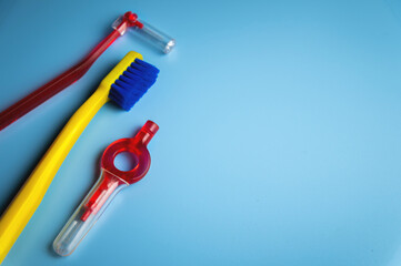 bright toothbrush, a red orthodontic interdental brush lie on a blue background, no people