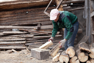 A young man is chopping wood with an axe
