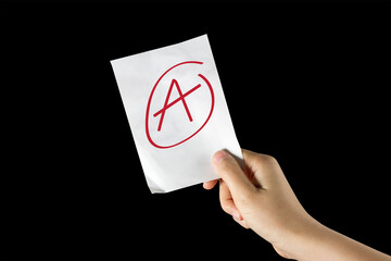 Hand holding a sheet of paper with grade A; Concept of quality, examination, evaluation
