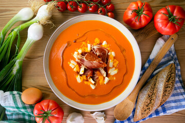 Salmorejo with ham and egg. Typical Spanish cold soup recipe made with tomatoes and vegetables. Traditional tapas from the south of Spain.