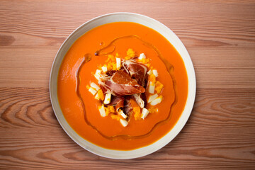 Salmorejo with ham and egg. Typical Spanish cold soup recipe made with tomatoes and vegetables. Traditional tapas from the south of Spain.