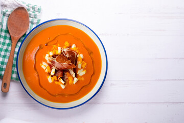 Salmorejo with ham and egg. Typical Spanish cold soup recipe made with tomatoes and vegetables....