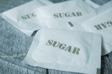 close up of white sugar in a paper packet on table 
