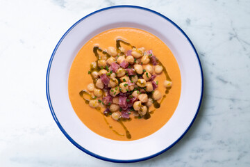Salmorejo with chickpeas and ham. Typical Spanish cold soup recipe made with tomatoes and vegetables. Traditional tapas from the south of Spain.