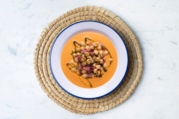 Salmorejo with chickpeas and ham. Typical Spanish cold soup recipe made with tomatoes and vegetables. Traditional tapas from the south of Spain.