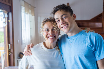 Portrait of middle age mother spend time with teenager son, relatives people hugging at home, adult...