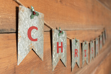 Close Up, Angled, Rustic Tin Christmas Bunting Hung on Wooden Wall With Copy Space