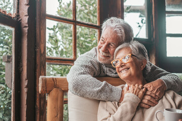 Portrait of couple of happy mature people in love hugging and looking at the camera smiling and...