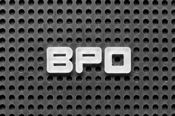 White alphabet letter in word BPO (Abbreviation of Business Process Outsourcing) on black pegboard...