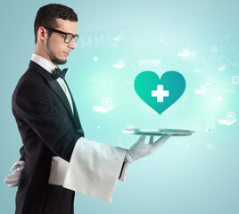 Handsome young waiter in tuxedo holding healthcare icons on tray