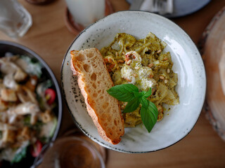 Directly above view of Green Ravioli pasta served on white plate, Topping with parmesan cheese, sweet basil and Grilled Slice bread