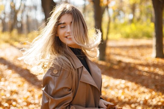 Portrait of a young woman posing for a photo in autumn park