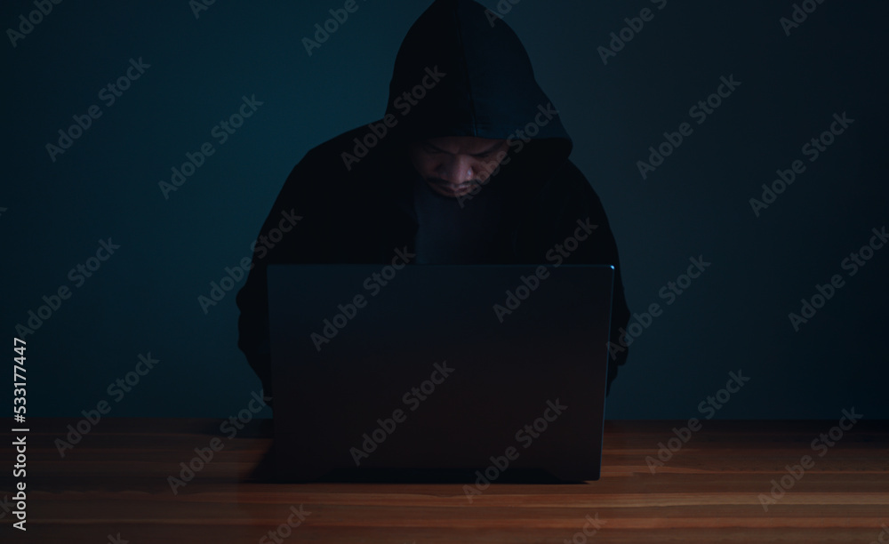 Poster hackers work on laptops in the dark. the concept of information security in the internet network and