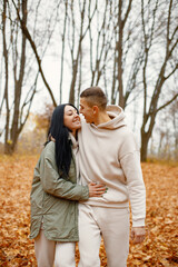 Fototapeta premium Lovely couple standing in autumn forest and kissing
