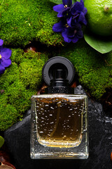 author selective perfume bottles around green moss, flowers and leaves  . close up. perfumery...