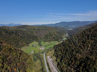 Aerial drone view road between hills with forest