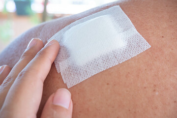 Senile fat women with a white bandage and young hand on the shoulder