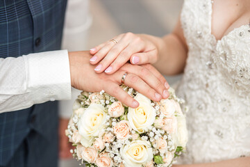Obraz na płótnie Canvas the bride and groom put their hands on the wedding bouquet