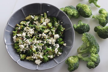 Broccoli with feta cheese. Sauteed broccoli florets sprinkles with served with crumpled feta cheese