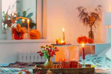 cup of tea and  chrysanthemum in vase with burning candles in bedroom