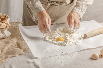 Women’s hands, flour and dough. A woman is preparing a dough for home baking. Concept of home cooking with organic and natural ingredients. Zero waste concept