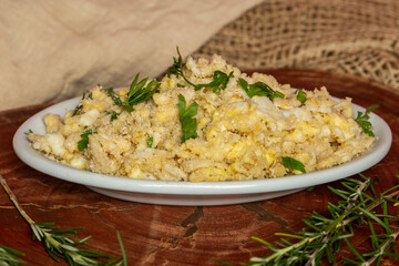 Portion of manioc farofa with eggs, typical Brazilian dish called farofa de ovos