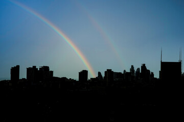 Rainbow in the city high rise silhouette scene