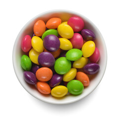 Colorful round candies in white bowl isolated on white. Top view.