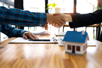 Real estate agents and customers shake hands together celebrating a finished contract after about home insurance and investment loan, handshake and successful deal