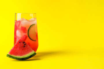 Fototapeta Tasty summer watermelon drink with lime in glass on yellow background. Space for text obraz