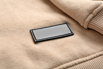 Blank clothing label on beige sweatshirt, closeup