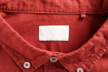 Blank clothing label on red shirt, top view