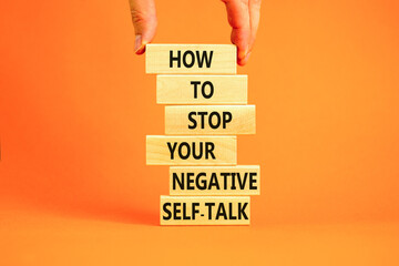 Stop negative self-talk symbol. Concept words Stop to flip your negative self-talk typed on blocks. Psychologist hand. Beautiful orange background. Psychological negative self-talk concept. Copy space