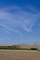 Fototapeta na wymiar Windmill in the field against the blue sky