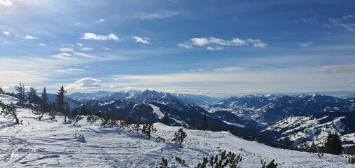 Panorama of the snow capped Alps and the view from the Griessenkareck summit near Flachau in Austria, on a sunny winter day.
