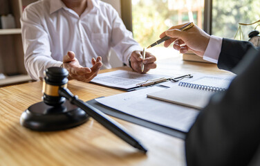 The business lawyer working about legal legislation in courtroom to help their customer, the Lawyer working with a client discussing contract paper
