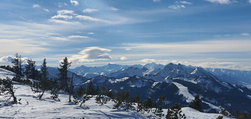 Panorama of the snow-capped Alps and view of the ski runs of Wagrain in Austria from the Griessenkareck summit on a sunny winter day.