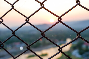 Fototapeta premium Fence grilles with sunset blur background