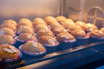 banana cake topping with almond on tray in hot oven.