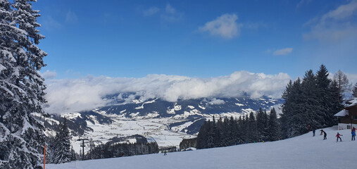 Panorama of the snowy Alps and view of the ski runs from the Griessenkareck peak near Flachau in Austria on a sunny winter day.