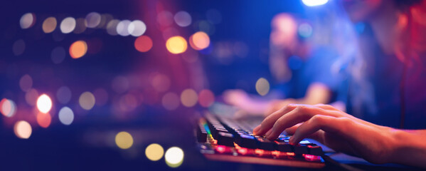 Banner professional cyber video gamer studio room with personal computer armchair, keyboard for stream in neon color blur background. Soft focus © Parilov